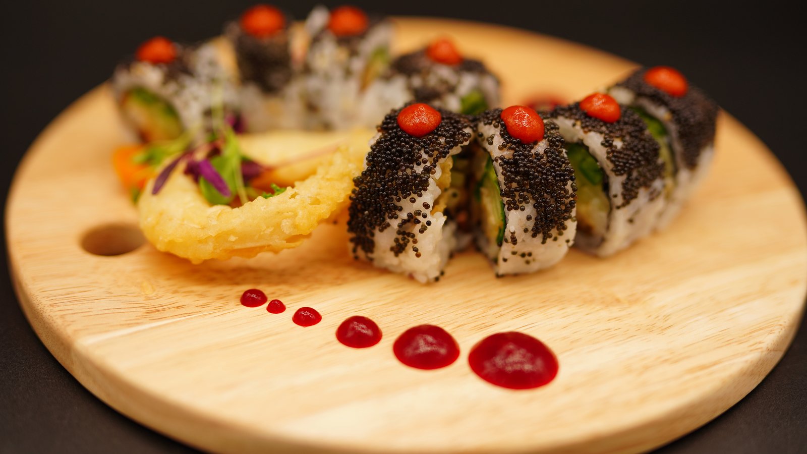 Artfully plated sushi rolls with tempura and sauce at HERS Sushi Bar and Ramen in Oregon WI