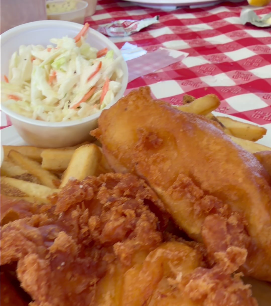 Beer battered cod with fries, coleslaw, and house made tartar sauce on a red checkered table at the Quivey's Grove outdoor fish fry in Fitchburg
