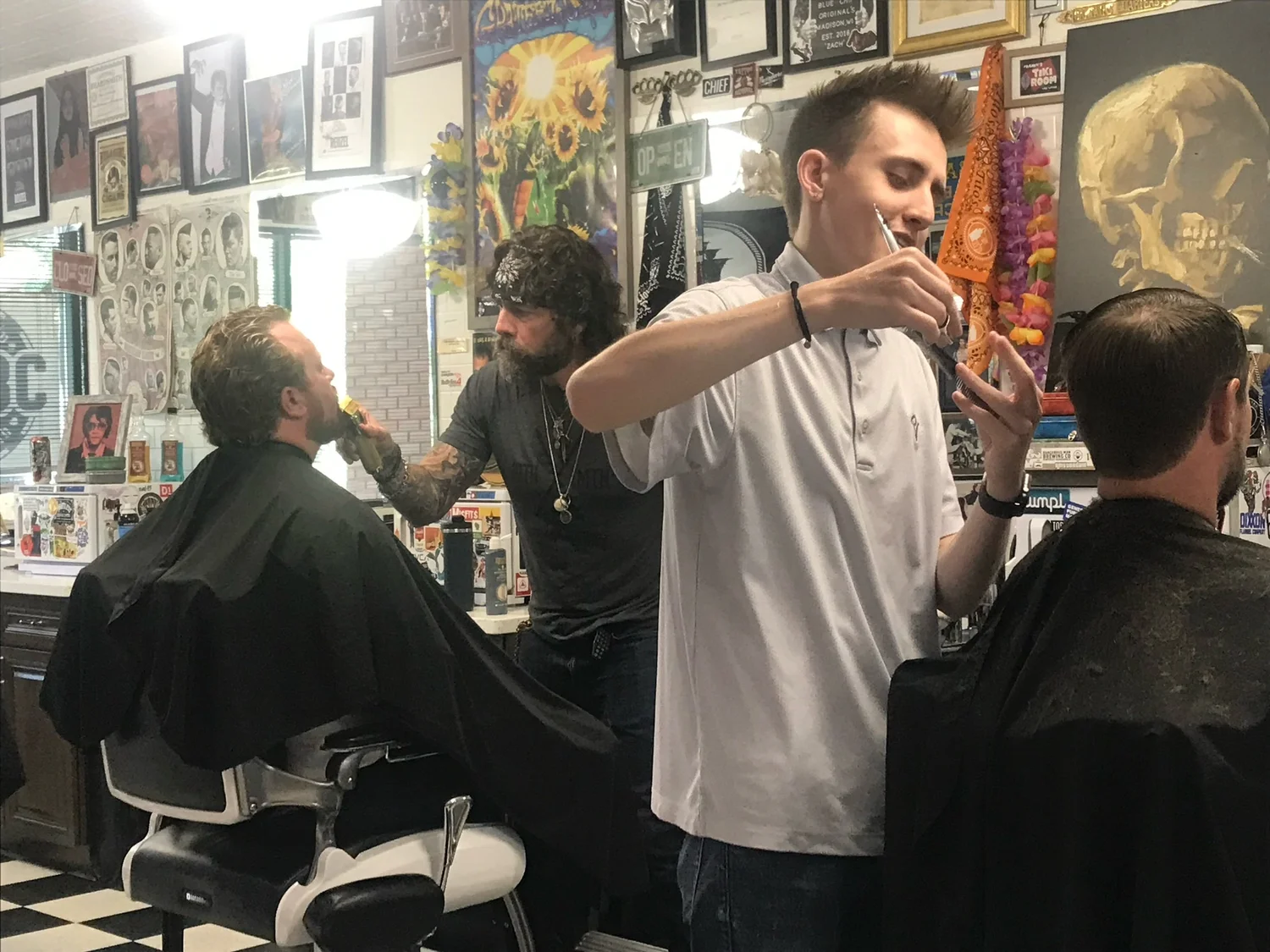 Barbers working inside Blue Chip Barber Club in Madison, Wisconsin with classic barbershop decor