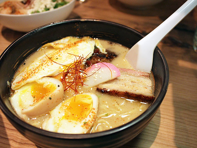 Ramen bowl with soft-boiled eggs, chashu, narutomaki and chili threads at Tochi Ramen