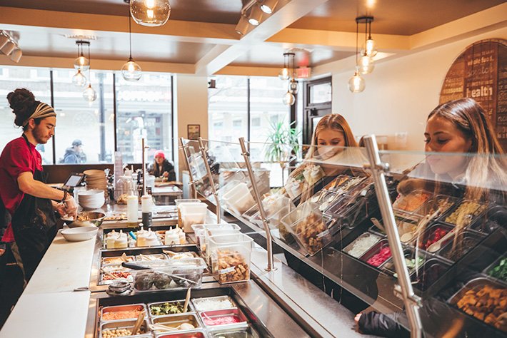 Fresh salad and bowl ingredient counter inside Forage Kitchen in Madison