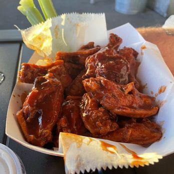 A platter of crispy buffalo wings with ranch, blue cheese and celery on a Wisconsin bar table
