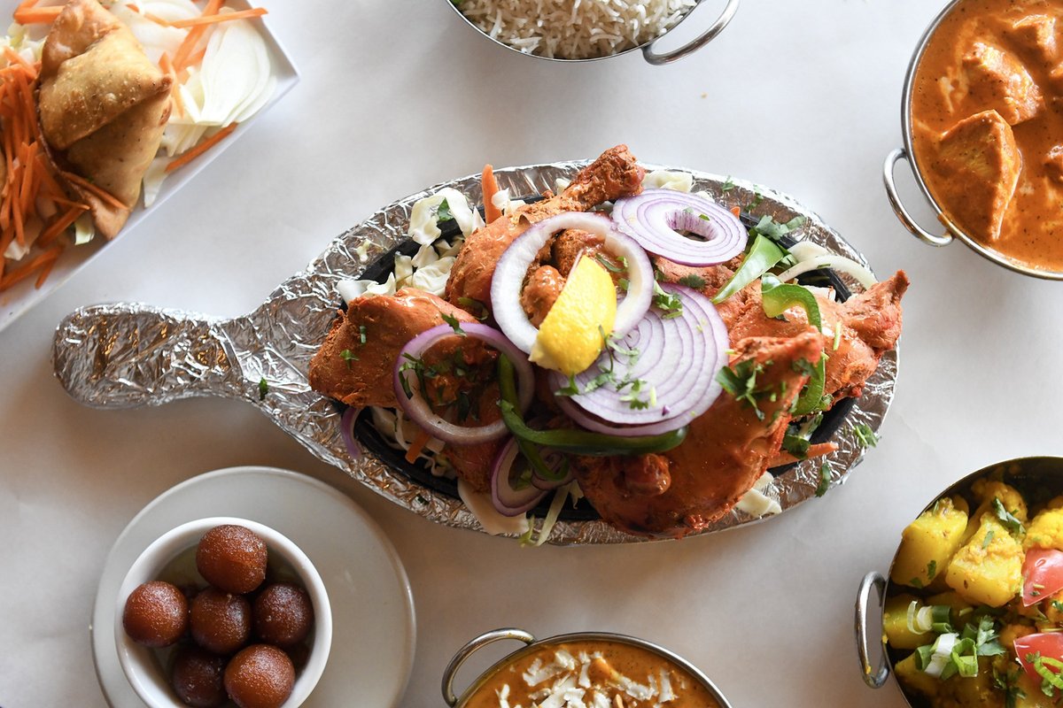 Tandoori chicken sizzler with samosas, curries, rice, and gulab jamun at Amber Indian Cuisine in Middleton